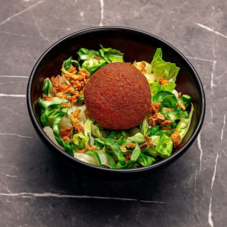 arancini volaille fromage sur un lit de salade accompagné d'oignons frits