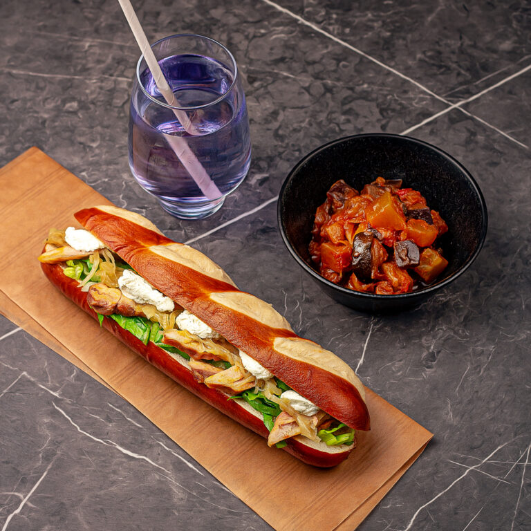 Menu composé d'un pain garni ni chaud ni froid, d'une portion de ratatouile et d'une boisson de sirop à l'eau