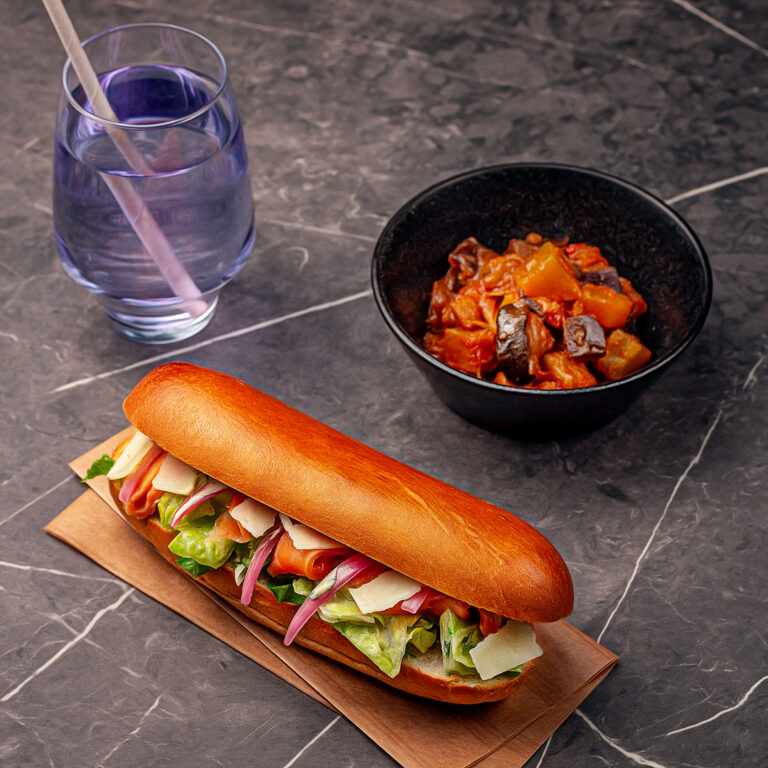 Menu composé d'un pain garni grand mer, d'une portion de ratatouille et d'une boisson de sirop à l'eau