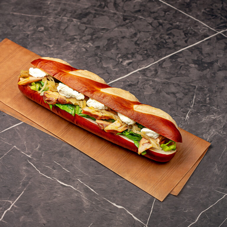 Long pain bretzel moelleux garnis de salade, émincé de volaille rôti, compotée d’oignons et fromage frais.
